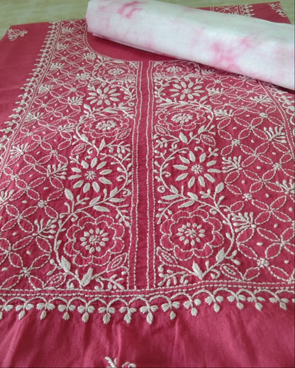 Pink fabric with white floral patterns on a wooden surface